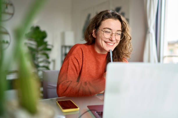 joven-estudiante-feliz-usando-computadora-portC3A1til-viendo-webinar-escribiendo-en-casa.jpg