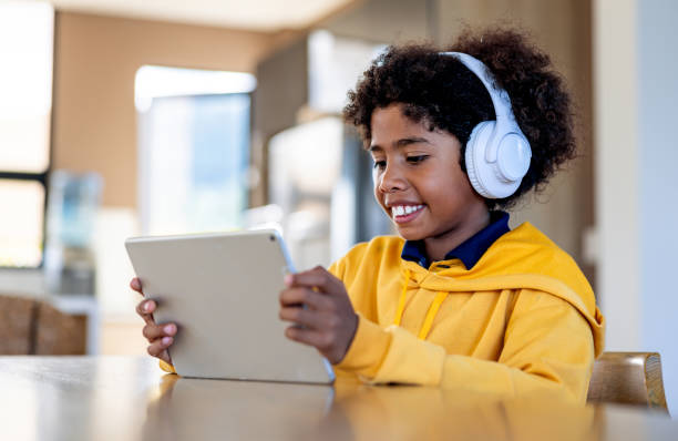 Niño feliz jugando en una tableta y aprendiendo acerca de cine y entretenimiento con Choco Inglés